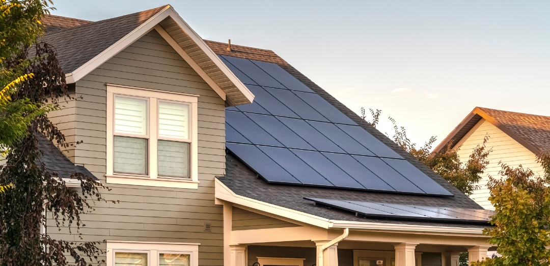 roof of house with solar panels at sunset
