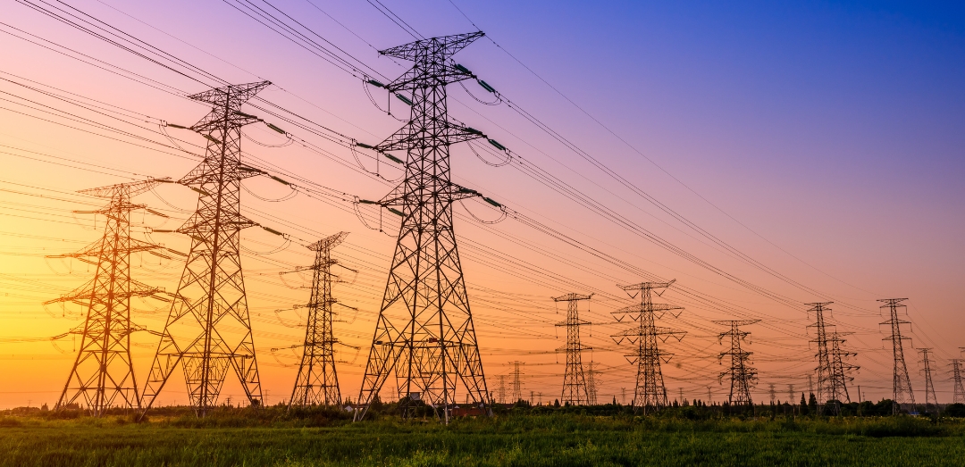 High-voltage power line and power transmission towers in a forest clearing
