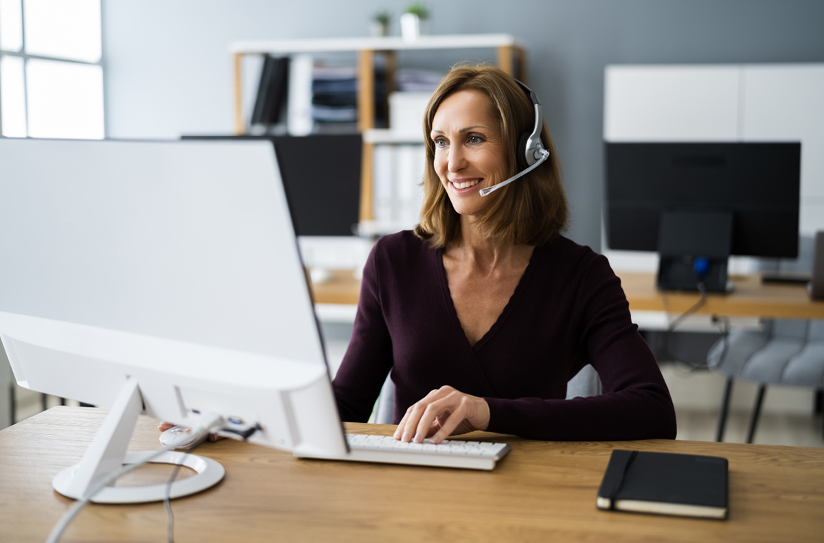 woman on desktop computer with headset having solar consultation call about commercial solar installation