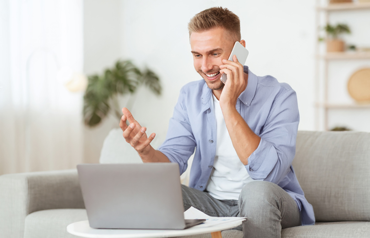 man on solar consultation call looking at laptop in living room