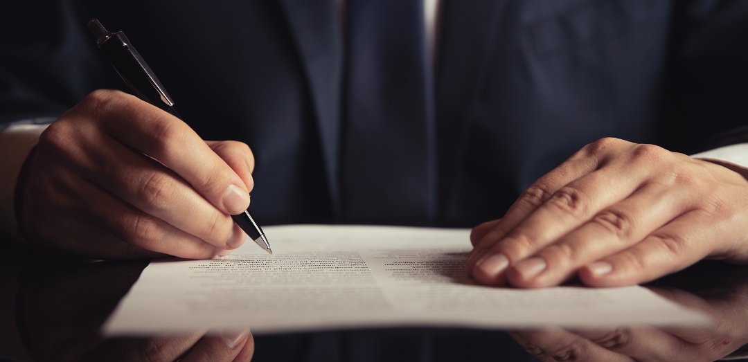 business man closeup on hand signing legal document OBBB energy tax credits bill